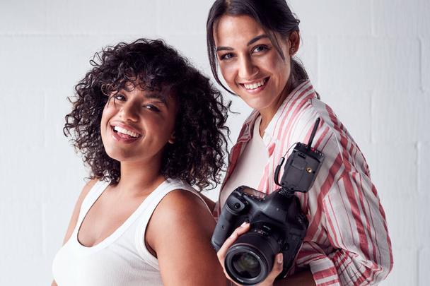 Portrait Of Smiling Female Photographer Holding Camera With Mode - Foto, Bild