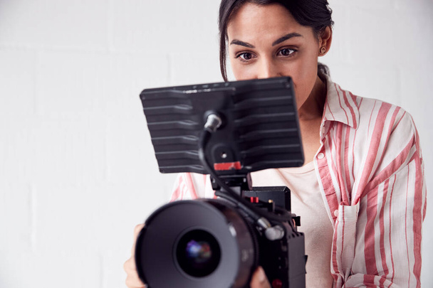 Female Videographer With Video Camera Filming Movie In White Stu - Foto, Bild