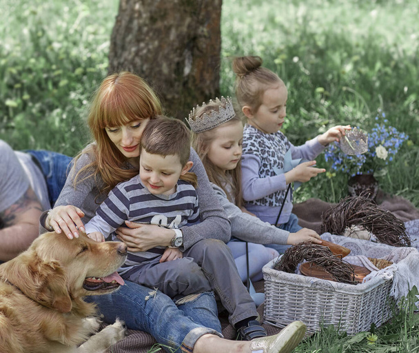 family with pet resting on the lawn. - Fotoğraf, Görsel