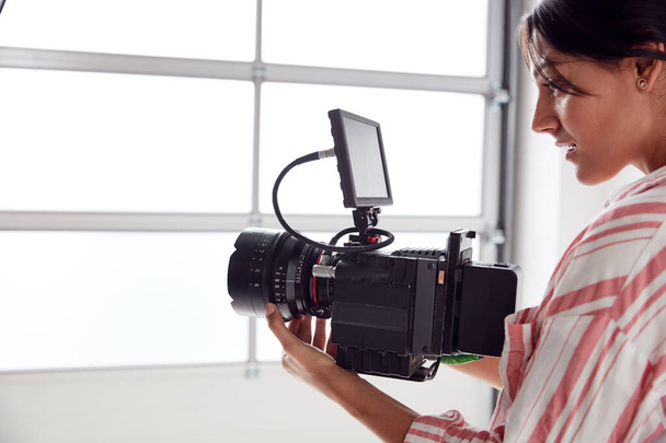 Female Videographer With Video Camera Filming Movie In White Stu - Valokuva, kuva