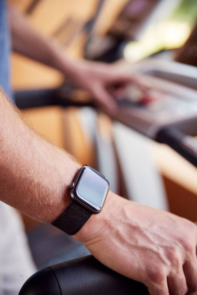 Close Up Of Man Exercising On Treadmill Wearing Smart Watch Checking Mobile Phone - Φωτογραφία, εικόνα