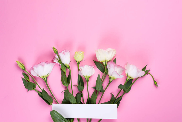 Határ keret készült eustoma virág rózsaszín háttér, lapos laikus. Virágdíszítő sarkok . - Fotó, kép