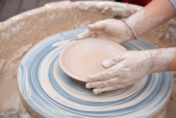 Mani che formano argilla sulla ruota della ceramica. - Foto, immagini