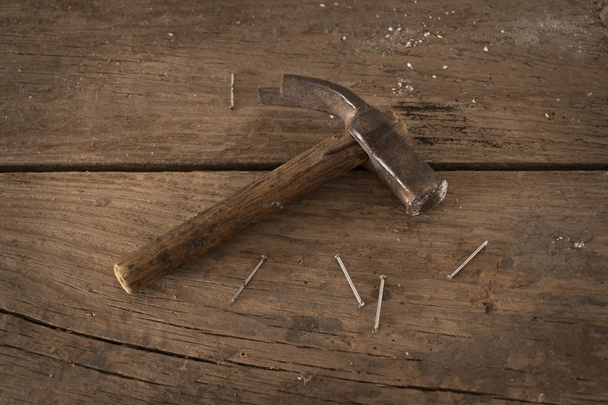 Old carpenter's hammer on wooden planks. Nails - Photo, Image