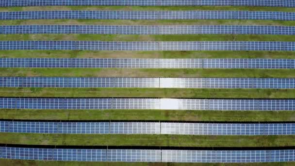 Aerial flying over a solar power plant. Sunlight is reflected of solar panels - Footage, Video