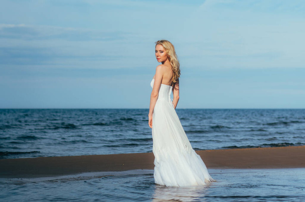 Portrait of young blond bride staying among the water - Foto, afbeelding