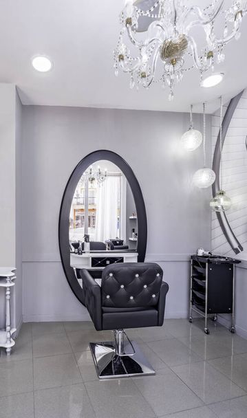 Modern bright beauty salon or baber shop. Hair salon interior business with black and white luxury decor. Detail of the chair and mirror - Foto, immagini