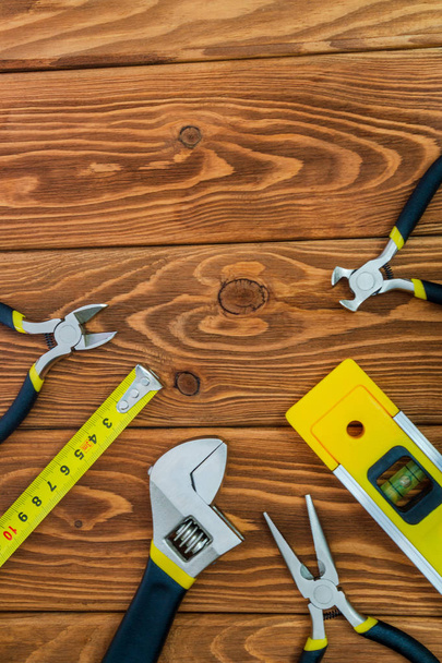 Инструменты для мастера-строителя подготовлены перед работой на коричневых деревянных досках
 - Фото, изображение