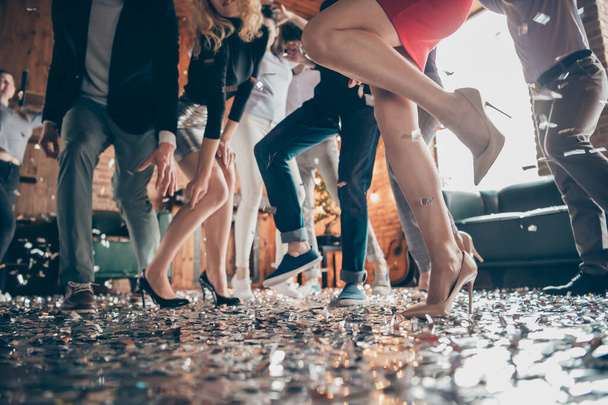 Low angle view cropped close-up photo of legs girls guys meeting rejoicing dance floor x-mas party glitter flying air wear formalwear high heels red dress silver skirt pants restaurant indoors - Zdjęcie, obraz