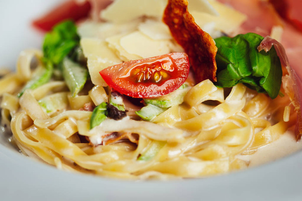 Fettuccine pasta with tomato and cheese in plate. - Fotografie, Obrázek