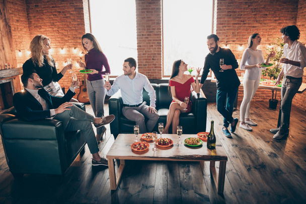 Photo of holiday birthday party eight people chatting clinking glasses drink golden wine eating snacks wear formalwear sitting sofa loft room restaurant indoors - 写真・画像