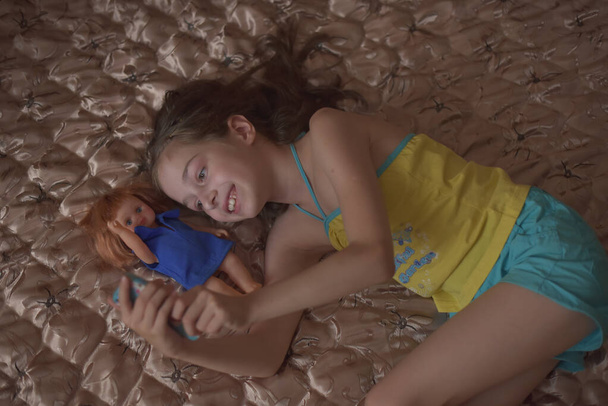 Красива молода жінка робить селфі за допомогою смартфона і посміхається, лежачи в ліжку
 - Фото, зображення