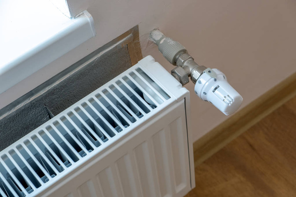 Fechar a válvula do radiador de aquecimento para re temperatura confortável
 - Foto, Imagem