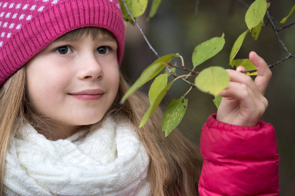 Bella bambina che indossa vestiti invernali caldi con branca d'albero
 - Foto, immagini