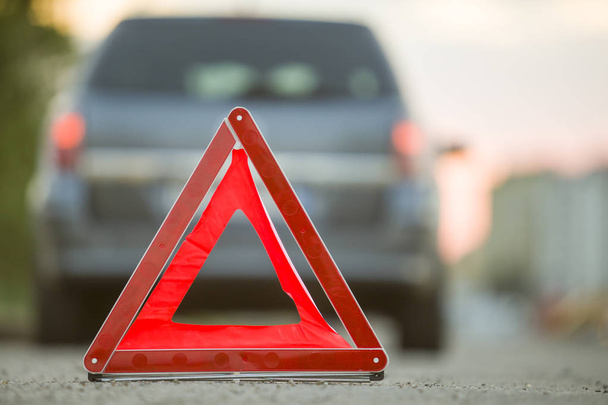 Czerwony trójkąt awaryjny znak stopu i uszkodzony samochód na ulicy miasta - Zdjęcie, obraz