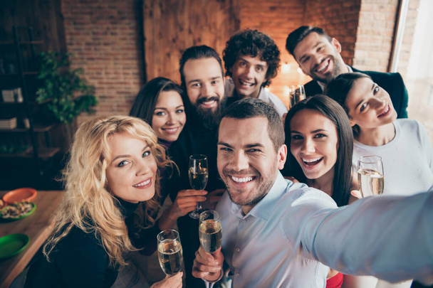 Photo of cheerful positive beautiful company of people holding glasses filled with champagne smiling toothily taking selfie - Photo, Image
