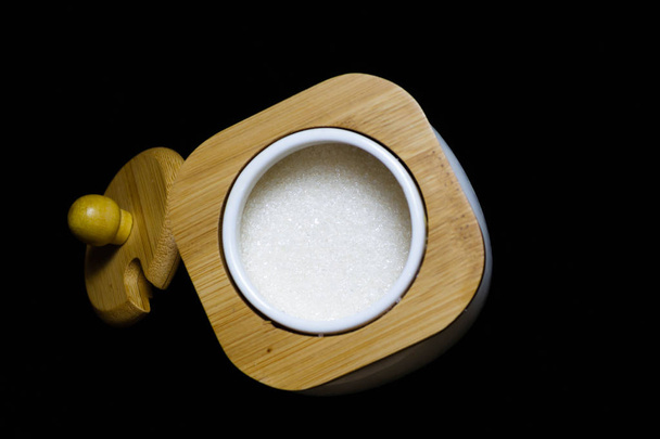 Sugar bowl with bamboo lid on a black background - Photo, Image