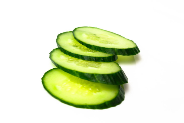 Ripe green cucumber on slices on a white background - Photo, Image