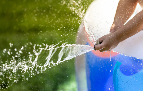 Kind spielt mit Wassersprenger im Garten - Foto, Bild