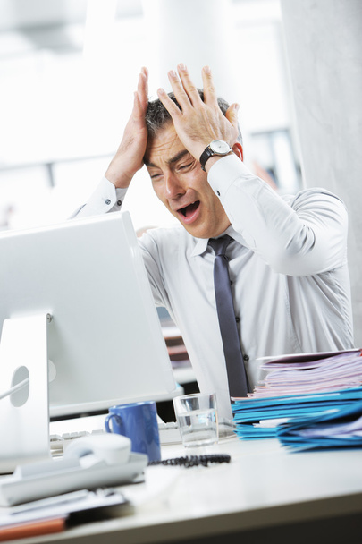 Frustrated Businessman sitting at desk in office - Zdjęcie, obraz