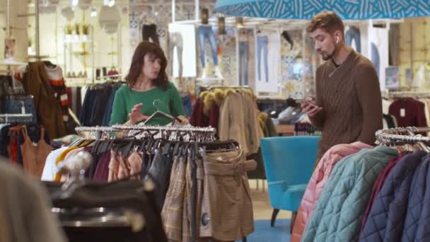 Nervózní žena a její muž v obchodě s oblečením  - Záběry, video