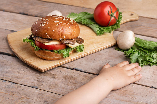 girls hand near onion and tomatoes, wooden table - Photo, Image