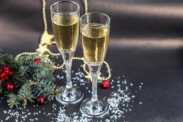 Christmas mood. Glasses with champagne. New Year. Christmas-tree decorations, coniferous branches. Copy space.  - Фото, изображение