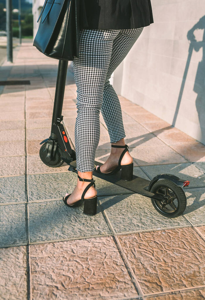 Onherkenbare zakenvrouw benen met e-scooter buiten - Foto, afbeelding