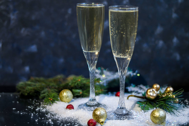 L'umore natalizio. Bicchieri con champagne. Capodanno. Addobbi per alberi di Natale, rami di conifere. Copia spazio
.  - Foto, immagini