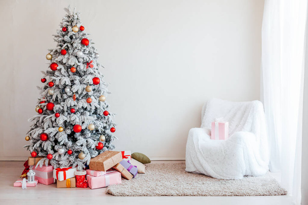 El árbol de Navidad en la habitación con los juguetes y los regalos la fiesta un nuevo año la postal invernal
 - Foto, imagen