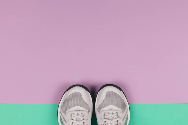 Grey sneakers on the violet and turquoise background. Concept for healthy lifestyle and everyday training.  - Photo, Image