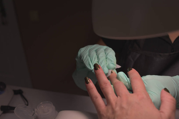 Woman hands receiving a manicure in beauty salon. Nail filing. Close up, selective focus. - Photo, Image