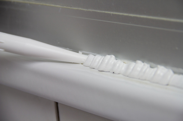Fermer Plombier appliquer un mastic silicone sur le comptoir et les carreaux de céramique. Amélioration de la maison, concept de rénovation salle de bains
 - Photo, image