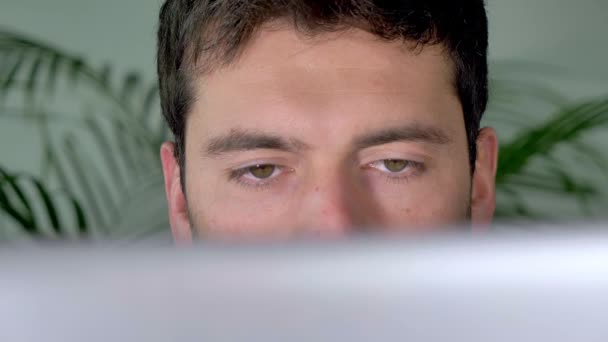Man Surfing Internet - це відео, яке показує чудові кадри чоловіка з сірими очима, який перевіряє Інтернет на своєму комп'ютері вдома. Цей відеоролик з 3840x2160 виглядатиме чудово у будь-якому відео-проекті, пов'язаному з Інтернетом та технологіями. - Кадри, відео