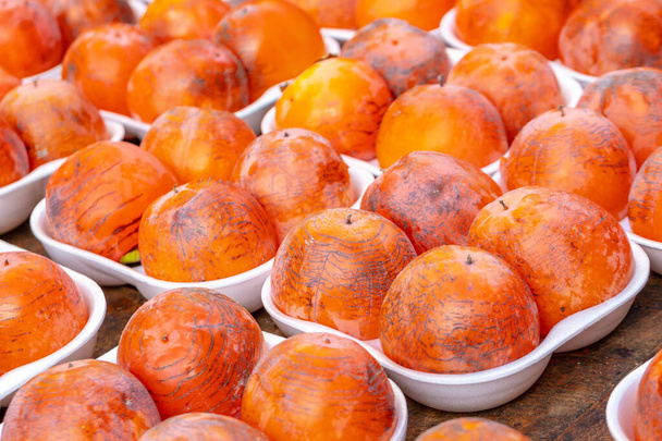 Řádky čerstvě zralé persimmon k prodeji na pouličním trhu - Fotografie, Obrázek