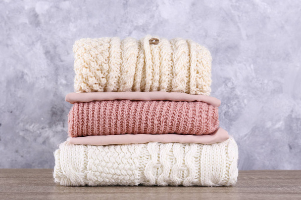 Set of different clothing folded in stack over textured wall background. - Photo, image