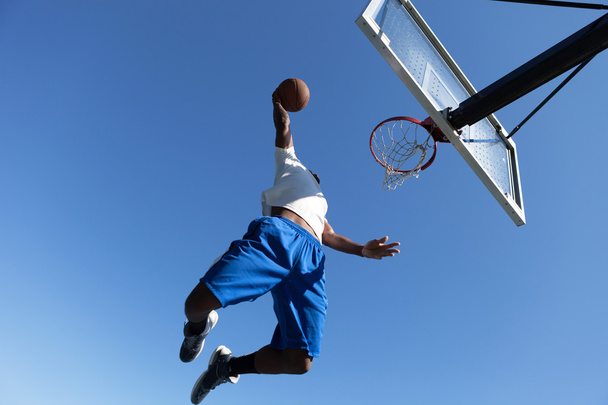 Uomo Dunking un pallacanestro
 - Foto, immagini