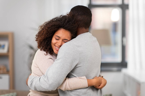 happy african american couple hugging at home - Foto, afbeelding