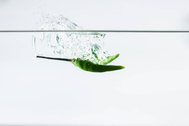 grüne Chilischoten, Wasserspritzer, isoliert auf weißem Hintergrund - Foto, Bild