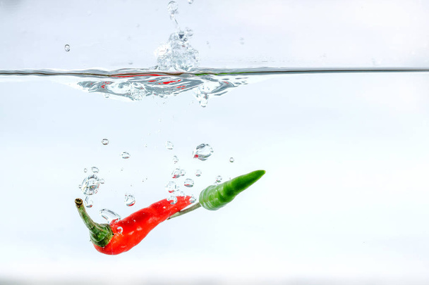 Red chilli, water splashes, solated on a white background - Foto, immagini