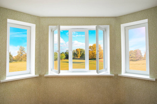 Blick durch ein geöffnetes modernes PVC-Fenster auf die wunderschöne Herbstlandschaft  - Foto, Bild