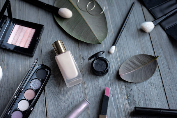 Makeup products flatlay on a wooden background. - Foto, afbeelding