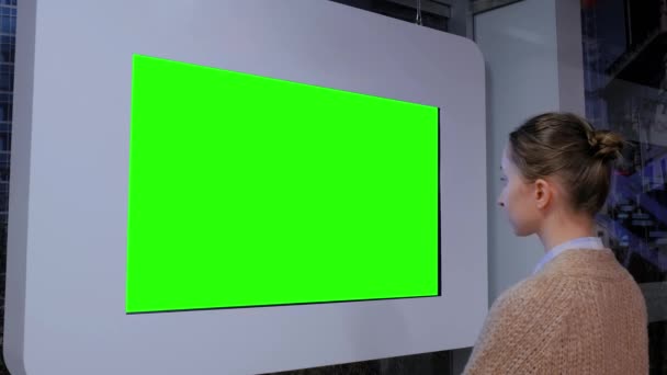 Nő néz üres zöld kijelző fal a kiállításon - zöld képernyő koncepció - Felvétel, videó