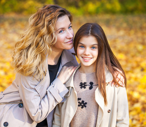 Onnellinen äiti ja tytär kävelevät syksyllä puistossa
 - Valokuva, kuva