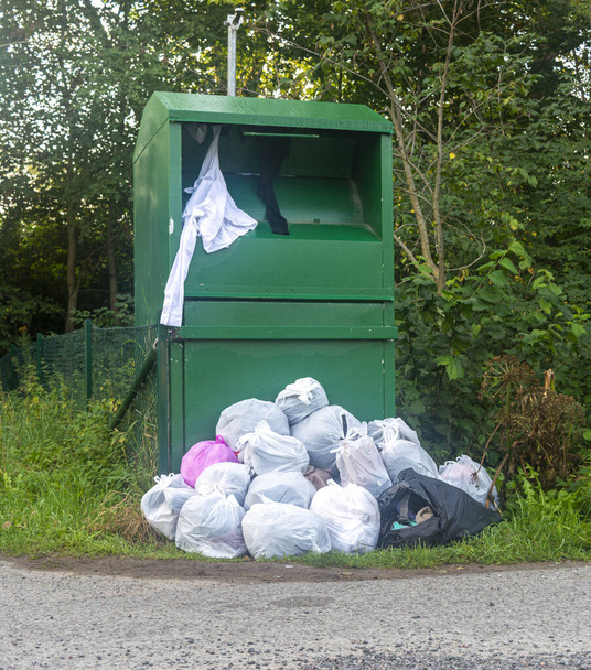 contenedor verde para ropa, bolsas de ropa en el primer plano de la calle
 - Foto, imagen