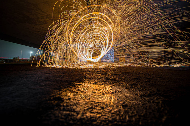 Light paint with spinning fire sparks that are jumping arround - Photo, Image