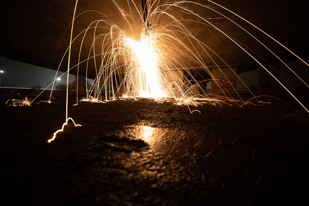 Light paint with spinning fire sparks that are jumping arround - Photo, Image