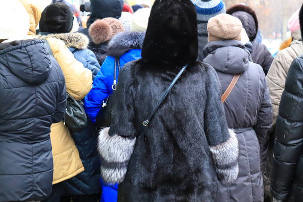 Talvella kaduilla on paljon ihmisiä. Ihmiset takit ja turkikset väkijoukko lähellä myymälää myynnissä. Ostajat tulevat ostarille Mustana perjantaina. Talvi, syksyn myynti, alennukset. Kiireiset ihmiset
 - Valokuva, kuva