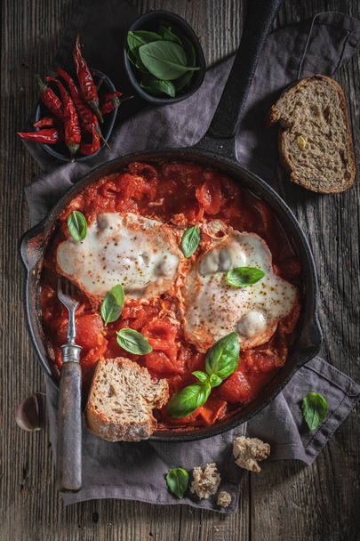 Hot shakshuka served with fresh wholemeal bread - Foto, afbeelding