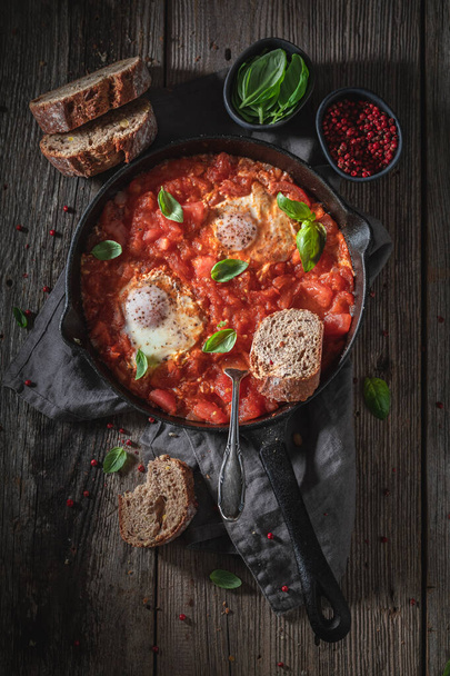 Hot shakshuka with eggs, tomatoes and herbs - Foto, Imagen